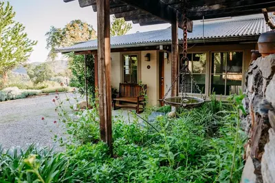 a house with a porch and a yard at Oak Meadows House - A unique home near Yosemite in Mariposa