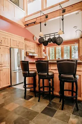 a kitchen with a table and chairs and a refrigerator at Oak Meadows House - A unique home near Yosemite in Mariposa