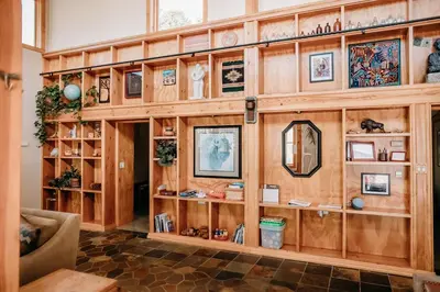 a room with a wooden wall with many shelves at Oak Meadows House - A unique home near Yosemite in Mariposa