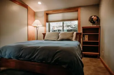 a bedroom with a large bed and a window at Oak Meadows House - A unique home near Yosemite in Mariposa