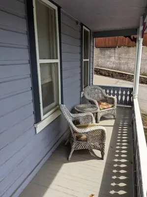 two wicker chairs sitting on the porch of a house at Yosomite Gateway Historic Victorian with Modern Touch in Sonora
