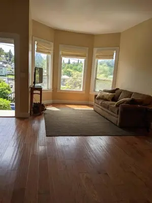a living room with a couch and two windows at Yosomite Gateway Historic Victorian with Modern Touch in Sonora