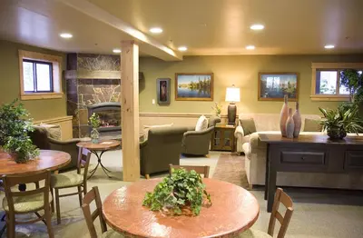 a living room with tables and chairs and a fireplace at GetAways at Olympic Village Inn in Olympic Valley
