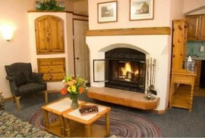 a living room with a fireplace and a couch at GetAways at Olympic Village Inn in Olympic Valley