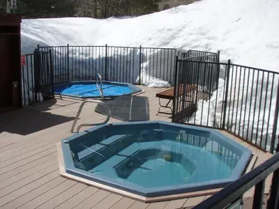 a jacuzzi tub on a deck with snow at GetAways at Olympic Village Inn in Olympic Valley