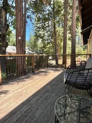 a wooden deck with two chairs and a table on it at Family get away Near Sly Park Lake & Apple Hill in Pollock Pines