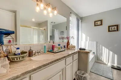 a bathroom with a sink and a large mirror at Water Views and Decks Spacious La Grange Retreat in La Grange