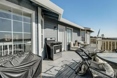 a motorcycle parked on a patio next to a house at Water Views and Decks Spacious La Grange Retreat in La Grange