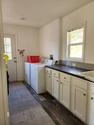 a kitchen with white cabinets and a black counter top at Majestic View in Mariposa