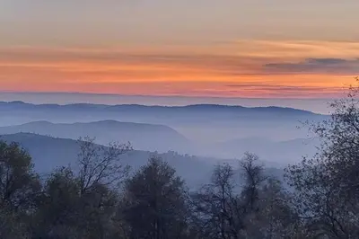 a view of a valley with trees in the foreground at Majestic View in Mariposa