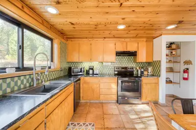 a kitchen with wooden cabinets and stainless steel appliances at Dwell by Tahoe Getaways - 3BR Tahoe Donner w Sauna & HOA Amenities in Truckee