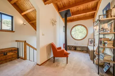 an office with an orange chair in a room with wooden ceilings at Dwell by Tahoe Getaways - 3BR Tahoe Donner w Sauna & HOA Amenities in Truckee