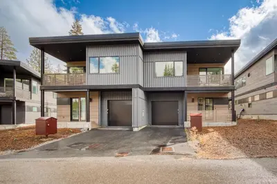 a large house with a parking lot at Lightning Run at Palisades - 3 BR 3 BA Condo steps to Palisades Tahoe- Ski Shuttle in Olympic Valley