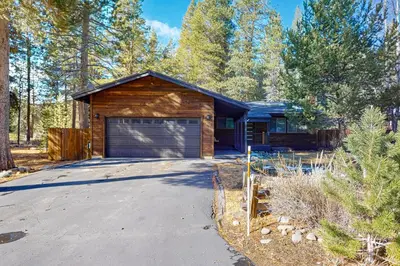a log house with a garage in the woods at Nature Lovers' Retreat in South Lake Tahoe