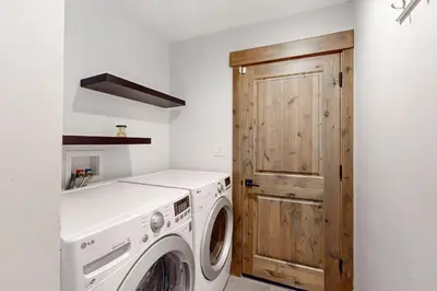 a laundry room with a washing machine and a wooden door at Nature Lovers' Retreat in South Lake Tahoe