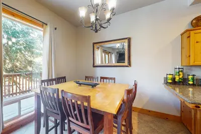 a dining room with a wooden table and chairs and a mirror at Baby Bear Bliss in Shaver Lake