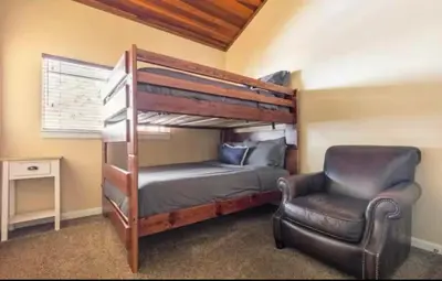 a bedroom with a bunk bed and a chair at Cozy Condo in Mammoth with 2 parking spots! Ski,Snowboard, Ice skate! in Mammoth Lakes