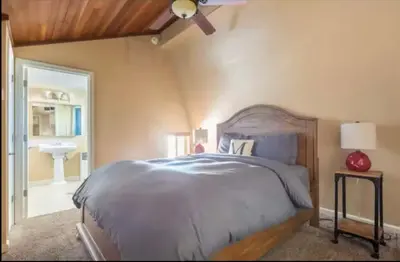 a bedroom with a large bed and a bathroom at Cozy Condo in Mammoth with 2 parking spots! Ski,Snowboard, Ice skate! in Mammoth Lakes