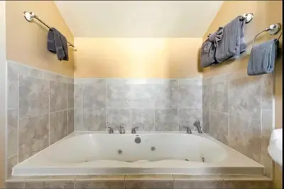 a bathroom with a large white tub in a room at Cozy Condo in Mammoth with 2 parking spots! Ski,Snowboard, Ice skate! in Mammoth Lakes