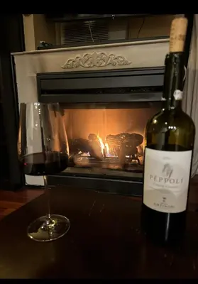 a bottle of wine and a glass of wine in front of a fireplace at Cozy Condo in Mammoth with 2 parking spots! Ski,Snowboard, Ice skate! in Mammoth Lakes
