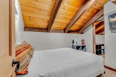 a bedroom with a white bed and wooden ceilings at Tahoe Condo Near Skylandia Beach in Tahoe City
