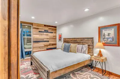 a bedroom with a bed and a wooden wall at Tahoe Condo Near Skylandia Beach in Tahoe City