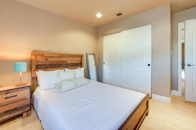 a bedroom with a large white bed with a wooden headboard at Ski Getaway with Hot Tub Reno Home By Attractions in Reno