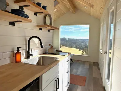 a kitchen with a sink and a large window at Wildhaven Yosemite Glamping in Mariposa