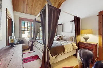 a bedroom with a canopy bed and a chair at Northstar Getaway in Truckee