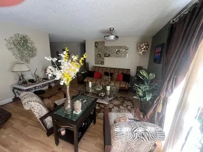 a living room with a table with flowers on it at Casa Pura Vida in Modesto