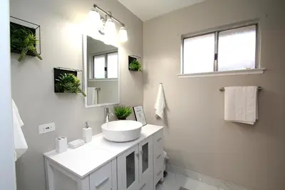 a white bathroom with a sink and a mirror at Entire Magill House by RiverPark in Fresno