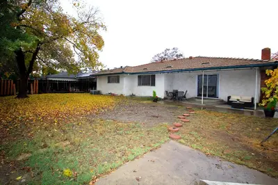 a house with a yard with leaves on the ground at Entire Magill House by RiverPark in Fresno