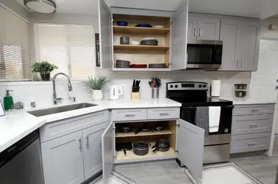 a kitchen with white cabinets and a sink at Entire Magill House by RiverPark in Fresno