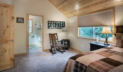 a bedroom with a bed and a chair and a window at 11N Margaret in North Wawona