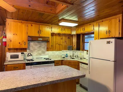 a kitchen with wooden cabinets and a white refrigerator at 10 Little Cabin In The Woods in North Wawona