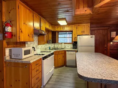 a kitchen with wooden cabinets and a white microwave at 10 Little Cabin In The Woods in North Wawona