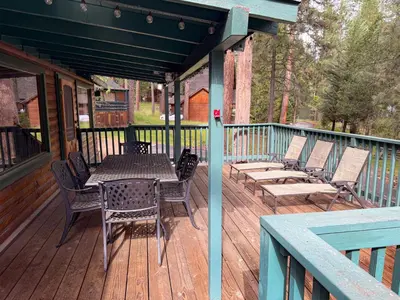 a wooden deck with a table and chairs on it at 10 Little Cabin In The Woods in North Wawona