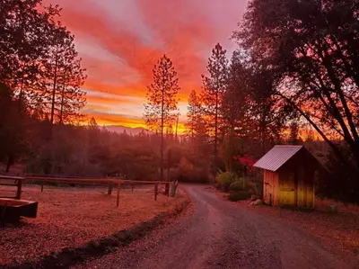 a dirt road with a barn and a sunset at Jordan Creek Ranch in Groveland