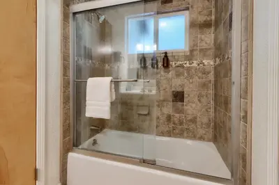 a bathroom with a glass shower with a tub at 17C The Redwoods Cabin in North Wawona