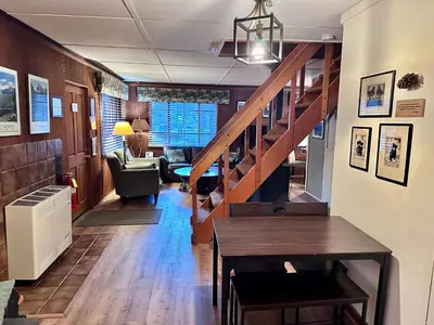 a hallway with a staircase and a living room at 1B Heart of the Meadow at The Redwoods In Yosemite in North Wawona