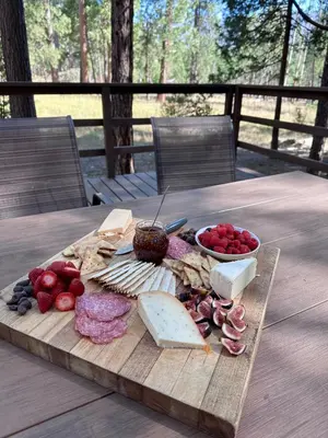 a cutting board with cheese and other foods on a table at 1B Heart of the Meadow at The Redwoods In Yosemite in North Wawona