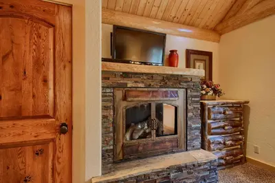 a stone fireplace with a television on top of it at Yosemite's Luxury Estate in North Wawona