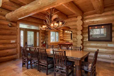 a dining room with a wooden table and chairs at Yosemite's Luxury Estate in North Wawona