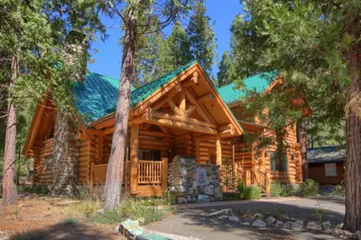 a log cabin with a green roof at Yosemite's Luxury Estate in North Wawona