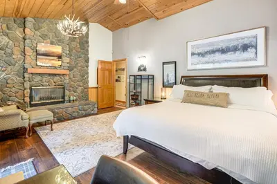 a bedroom with a bed and a stone wall at Fire Pit, Gazebo and Grill Family Cabin in Arnold! in Arnold