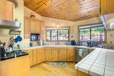 a large kitchen with wooden cabinets and a wooden ceiling at Fire Pit, Gazebo and Grill Family Cabin in Arnold! in Arnold