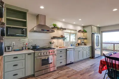 a kitchen with white cabinets and a stove top oven at Ski, Hike and Fish Mtn-View Gem with Deck in Tuolumne in Tuolumne