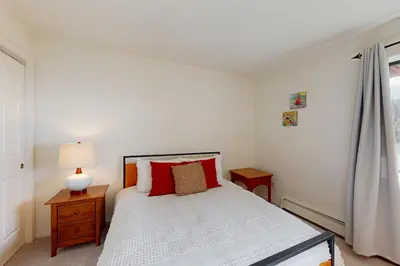 a bedroom with a white bed with red pillows at Bear-foot Retreat in Incline Village