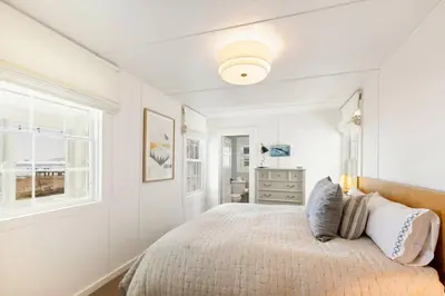 a white bedroom with a bed and a window at Belleview Lakefront by Tahoe Getaways - Hot Tub, Pier, Buoy and Guest House in Homewood
