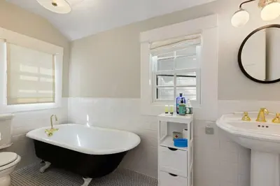 a bathroom with a black and white tub and a sink at Belleview Lakefront by Tahoe Getaways - Hot Tub, Pier, Buoy and Guest House in Homewood